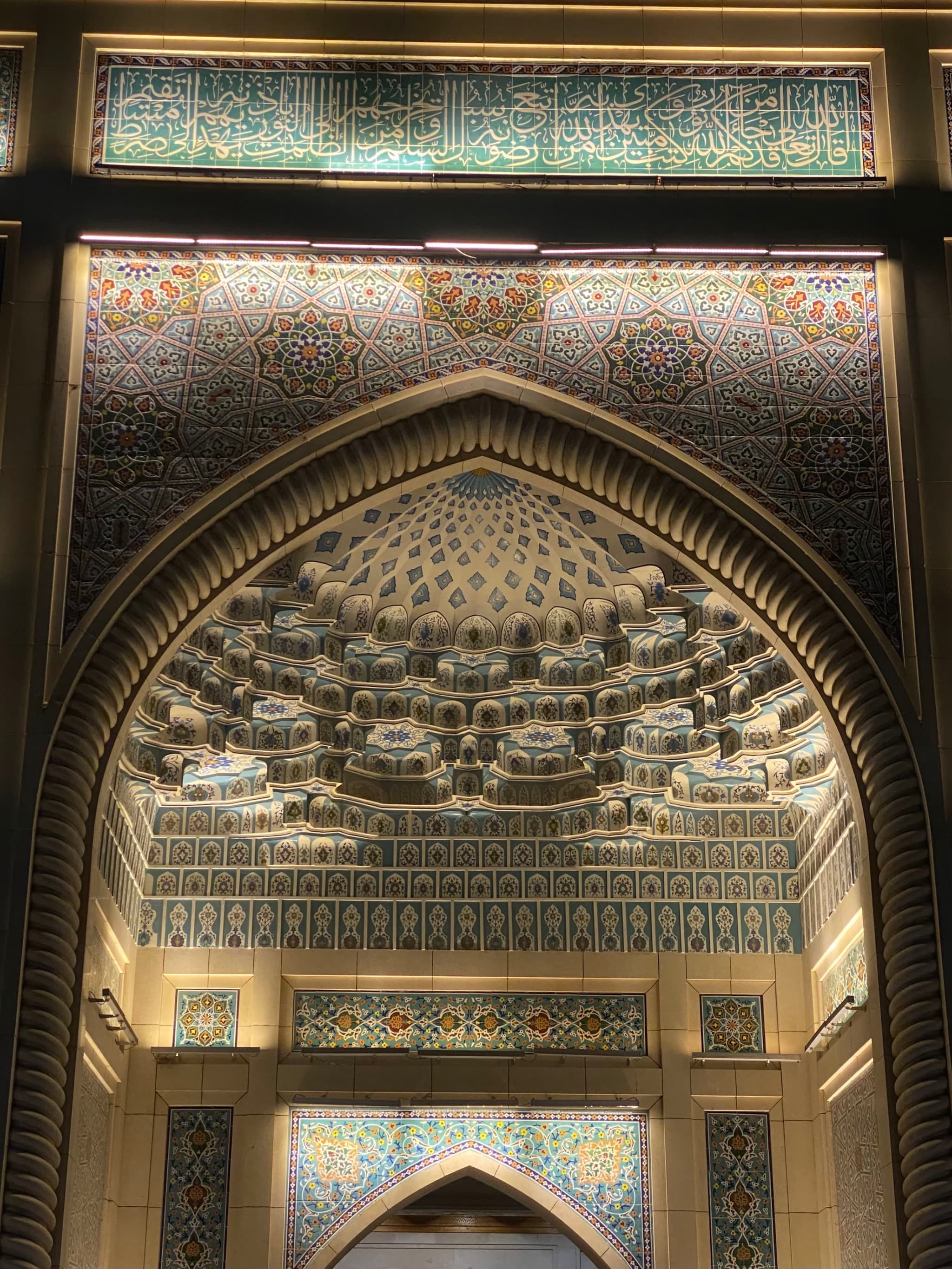 Elegant ornate archway with intricate tilework and patterns, bathed in warm, natural light, evoking a serene and historic atmosphere