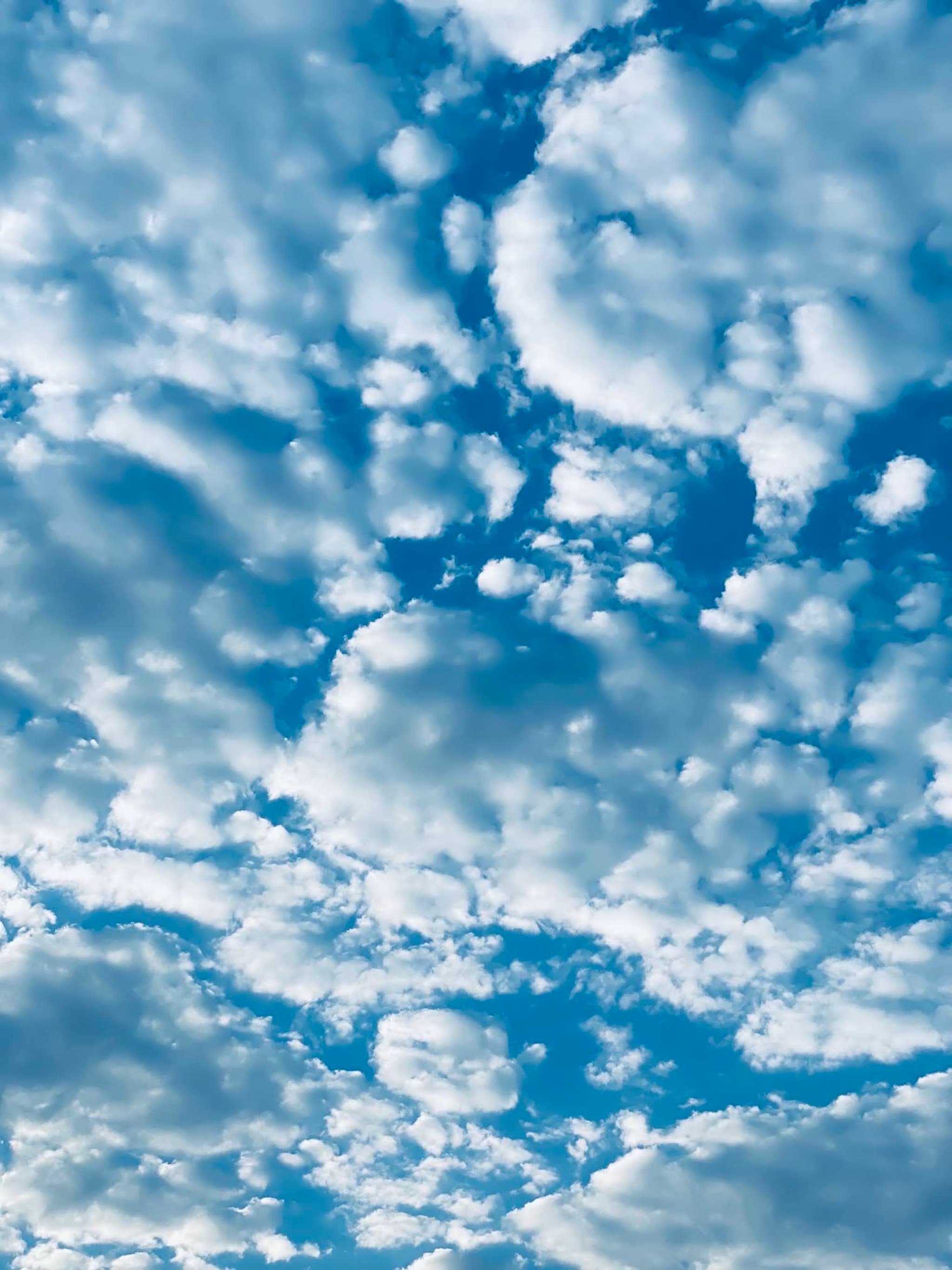 A serene sky with fluffy white clouds against a deep blue backdrop, evoking a peaceful and tranquil mood