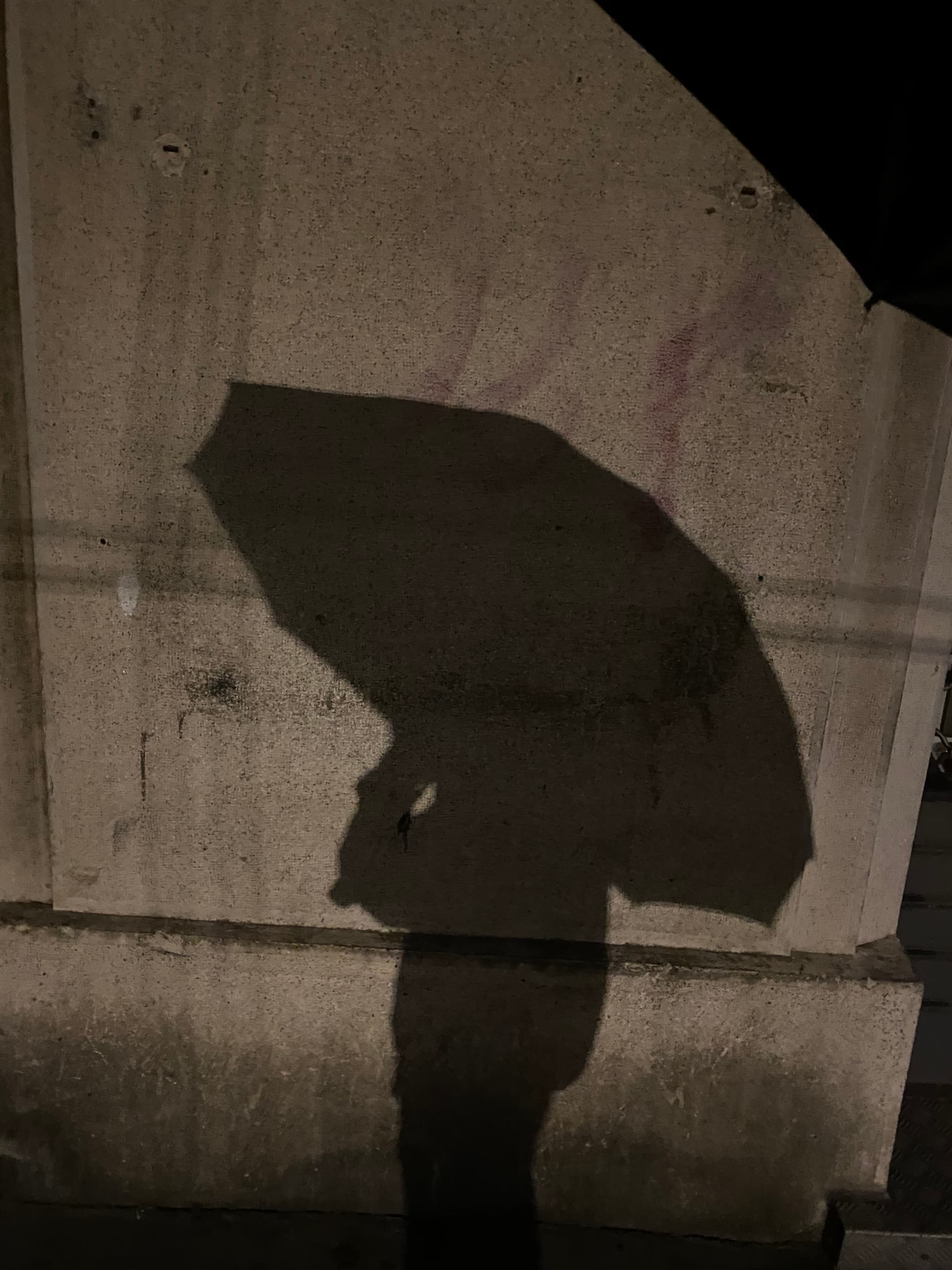 Dark, rainy scene with a large umbrella silhouette, faint street lights, wet pavement, and eery atmosphere