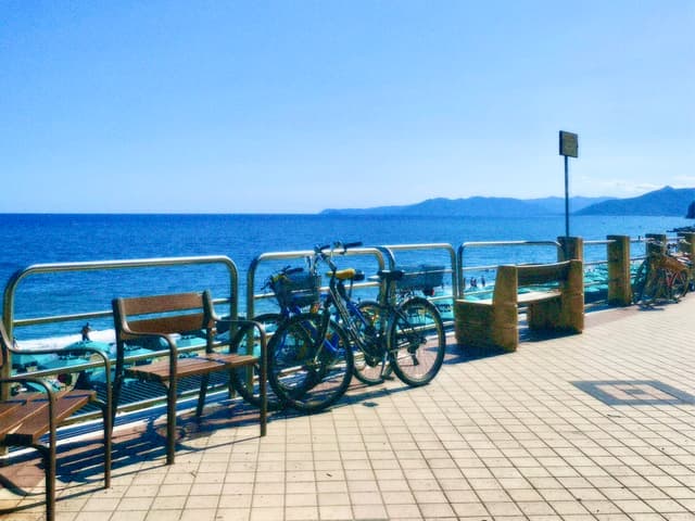 Bicycles on sunny seaside promenade with clear blue sky, reflecting tranquility and leisure