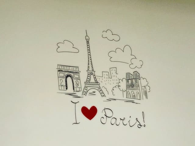 Hand-drawn Paris sketch with Eiffel Tower, Arc de Triomphe, and I ♥ Paris! text, set against a clean white background